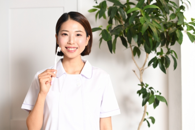 笑顔で歯ブラシを持つ女性